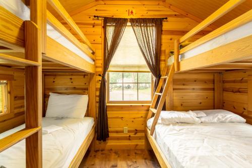 盖茨堡Drummer Boy Camping Resort的木制客房设有两张双层床和窗户。