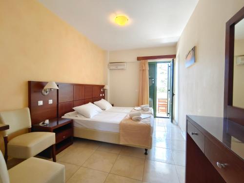 卡尔帕索斯亚历克斯酒店的卧室配有1张床、1张桌子和1把椅子