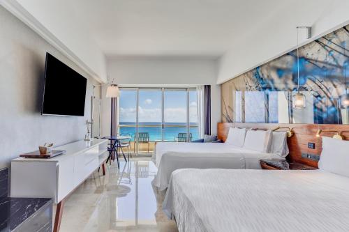 坎昆坎昆水上生活海滩度假村的酒店客房设有两张床和电视。