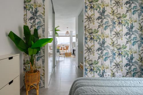 大加那利岛拉斯帕尔马斯Stylish Sea View Accommodation Las Canteras的一间拥有蓝白色壁纸和植物的卧室