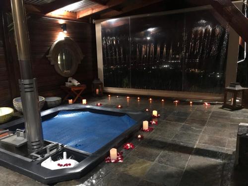 克尼斯纳Knysna Lodge - Self Catering Unit with Woodfired Hot Tub的一间带蜡烛的游泳池的房间和一间带游泳池的房间