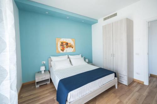 安齐奥Stampeggioni Appartamenti的蓝色的卧室,配有一张蓝色墙壁的床