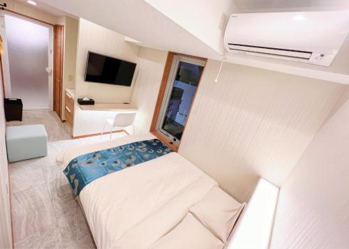 埼玉市HOTEL MOND Omiya - Vacation STAY 85327v的小房间设有床铺和电视