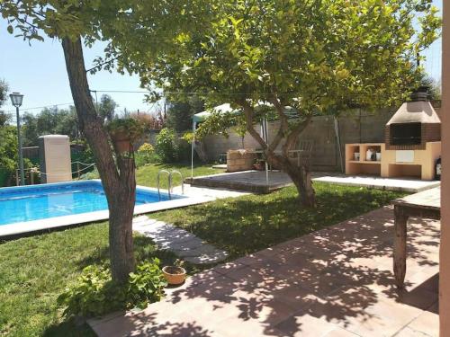 赫雷斯-德拉弗龙特拉Vivienda Rural La choza的后院设有游泳池和两棵树