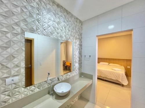 卡斯卡韦尔Hotel Armenia的一间带水槽和镜子的浴室以及一张床