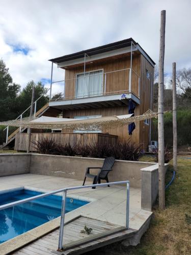 坦迪尔al pie de las sierras en villa del lago的房屋旁带游泳池的房子