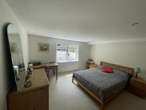 伦敦Spacious Holiday Home!的一间卧室配有一张床、一张书桌和一个窗户。