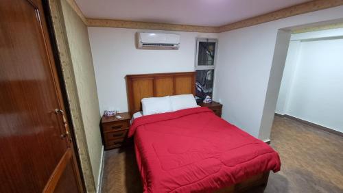 亚历山大Smouha studo apartment - families only的一间卧室配有一张带红色毯子的床