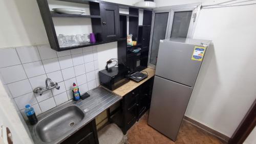 亚历山大Smouha studo apartment - families only的一间带水槽和冰箱的小厨房