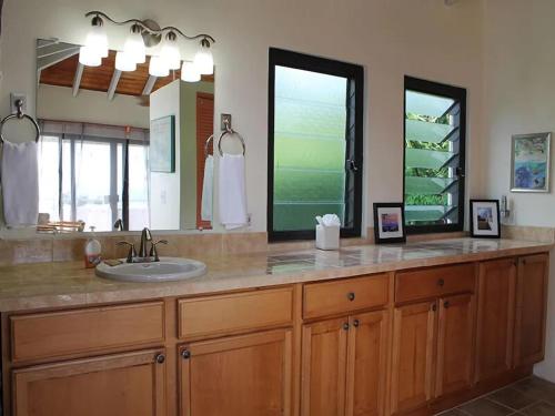 Cruz BaySunset Ridge Villa D的一间带水槽和大镜子的浴室