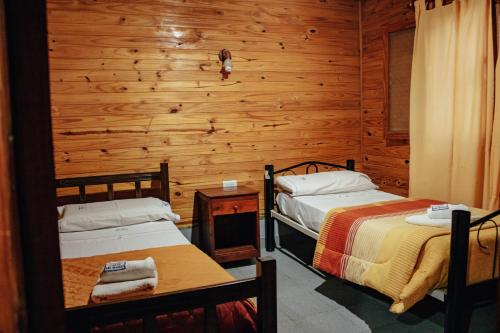 卡法亚特Cabañas y Hostal Las Marias的一间卧室设有两张床和木墙