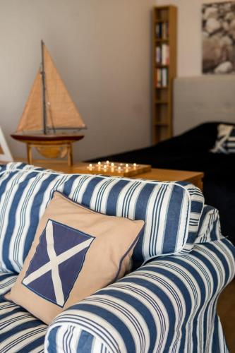 纳坦利Lillmåsen Naantali - atmospheric and very comfy studio的客厅配有带蓝色和白色枕头的沙发