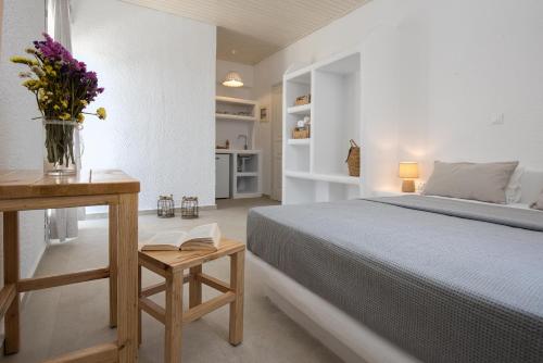 米科利维亚Vavoulas Village的一间卧室配有一张床和一张花瓶桌子