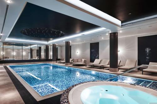 华沙Radisson Collection Hotel, Warsaw的一座大型游泳池,位于一座配有浴缸的建筑内
