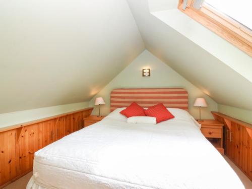DunsThe Coach House的卧室配有白色床和2个红色枕头
