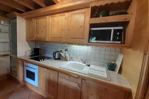 拉克吕萨Quiet apartment near the slopes的一个带木制橱柜和水槽的厨房