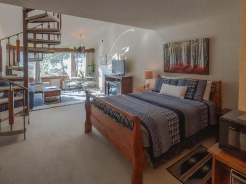 杜兰戈Tamarron Lodge Loft 314的一间卧室设有一张床和一个楼梯,还有一个客厅