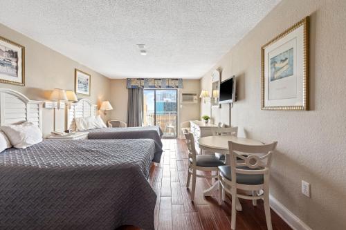 默特尔比奇Driftwood 51009的酒店客房带两张床和一张桌子以及椅子。