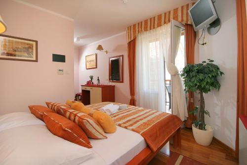 特罗吉尔托里吉尔酒店的一间卧室配有带橙色枕头的床