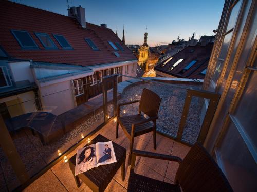布拉格布拉格EA大使酒店的阳台配有椅子和书本