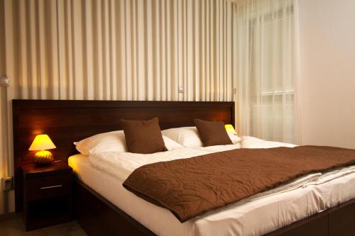 特尔纳瓦有家公寓式酒店的一间卧室配有一张大床、一盏灯和一扇窗户