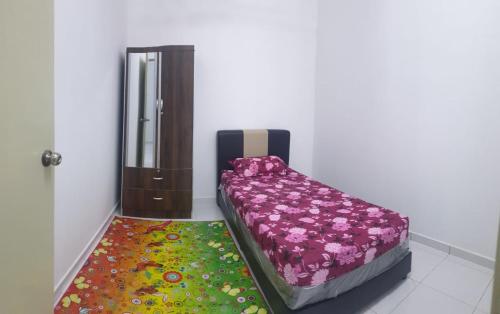 斯里曼绒HOMESTAY IMPIAN QASEH MANJUNG (MUSLIM)的一间设有床和色彩缤纷地毯的房间