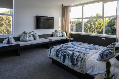 悉尼Beach Road Hotel的一间卧室设有一张床、一台电视和窗户。