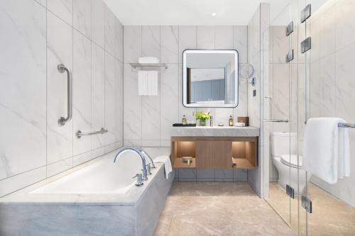成都成都盛捷高新服务公寓的带浴缸、盥洗盆和卫生间的浴室