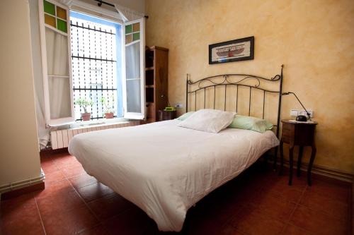 巴塞罗那蓝色度假屋的卧室设有一张白色大床和两个窗户。