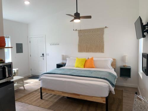 熔岩温泉村Winzig Lodge的一间卧室配有带色彩缤纷枕头的床。