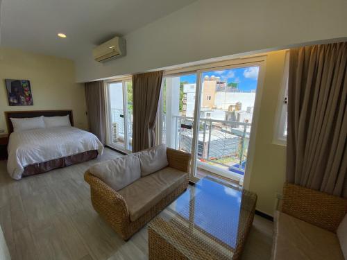 南湾乐逸行旅南湾馆 的一间卧室配有一张床、一张沙发和一个窗口