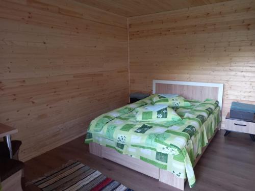 伊兹沃鲁穆列什鲁伊Cabanele Areama Neagra的木制客房内的一间卧室,配有一张床