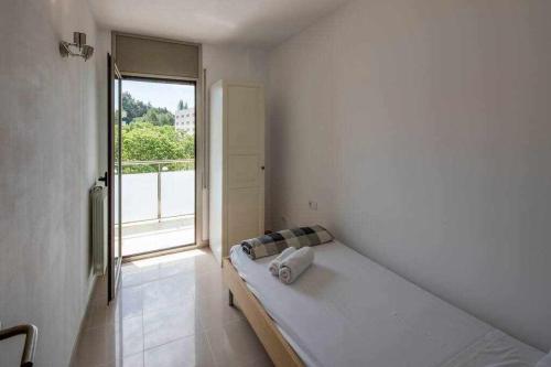 赫罗纳Apartamento Riu Fluvià Girona的白色的客房设有床和窗户。