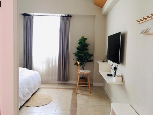 金沙镇蜜丽居的一间卧室配有一张床和一台平面电视