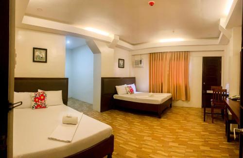 爱妮岛Jurias Garden Hotel的酒店客房设有两张床和一张桌子。