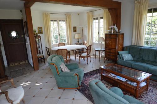 图尔热维尔Villa sur la plage的客厅配有沙发、椅子和桌子