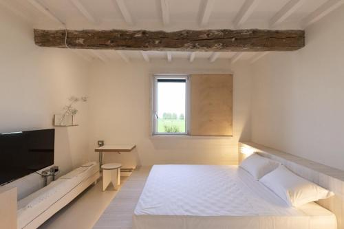 瓜斯塔拉La Pervinca - Ospitalità, Natura, Cura的一间白色卧室,配有床和电视