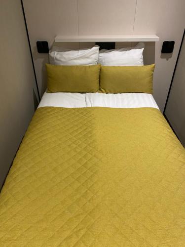 阿姆斯特丹Cityview Hotel的一张大床,配有黄色床单和枕头