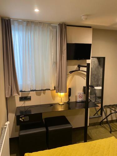 阿姆斯特丹Cityview Hotel的客房设有沙发和带窗户的书桌。