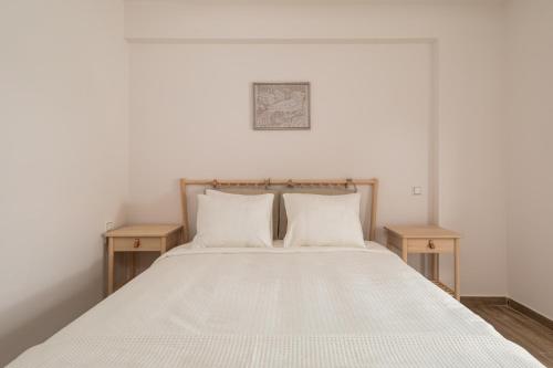 约阿尼纳My Oneiro City Apartments的一间卧室配有一张带两张木桌的床