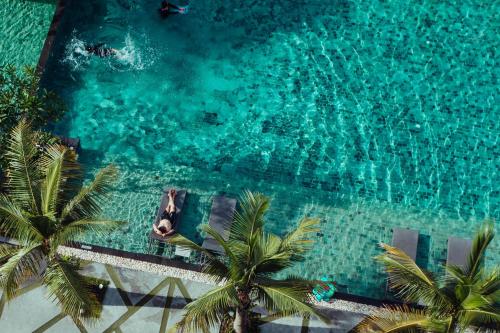 华欣G 华欣度假酒店及购物中心的享有棕榈树游泳池的顶部景致