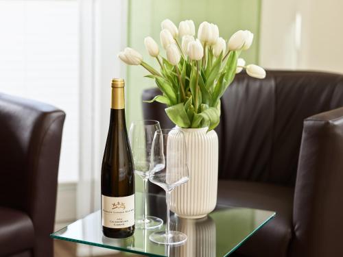 皮斯波尔特Kettern Urlaub的一瓶葡萄酒和一瓶白花在桌子上