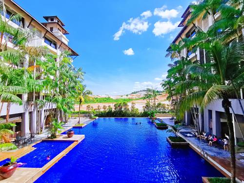 士姑来【Amazing】Pool View 2BR Suite @ Pulai Springs Resort的棕榈树两栋建筑之间的游泳池