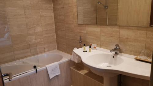 默伦大君主酒店的浴室配有盥洗盆和浴缸。