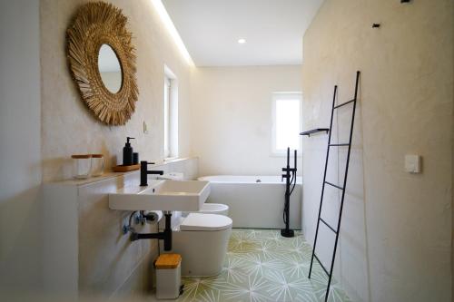 阿尔热祖尔Birds of Paradise的浴室配有盥洗盆、卫生间和浴缸。