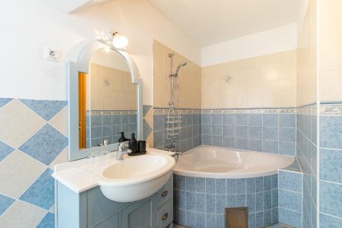 拉多夫吉卡兰克塔膳食公寓的蓝色瓷砖浴室设有水槽和浴缸