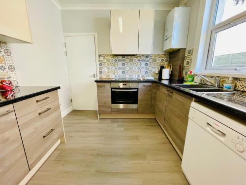 朴次茅斯Clive Crest house的厨房配有白色橱柜和水槽