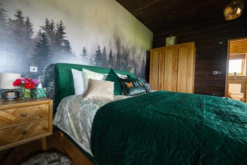 StoneLuxury Log Cabin with a Hot Tub的一间卧室配有一张带绿色棉被的床