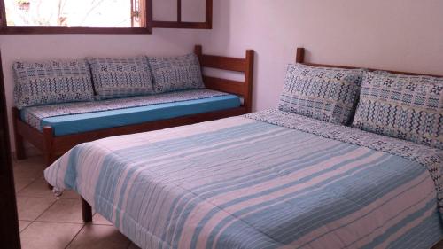 博拉塞亚Chalés Ancoradouro的一间卧室配有两张带枕头和长凳的床