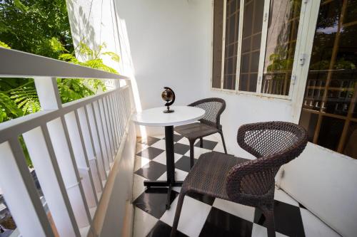 芽庄Nhà đầy nắng homestay的阳台配有一张小桌子和两把椅子